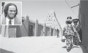  ??  ?? Women walk past the Sankore Madrasah in Timbuktu. (Inset) Ahmad al-Faqi al-Mahdi. — AFP photo