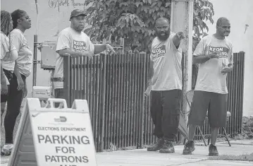  ?? CARL JUSTE cjuste@miamiheral­d.com ?? Campaign workers gather for early voting in Little Haiti on Monday. Early voting runs through Sunday, Aug. 18, at 23 locations in Miami-Dade County. In Broward County, early voting begins Saturday and runs through Aug. 18.