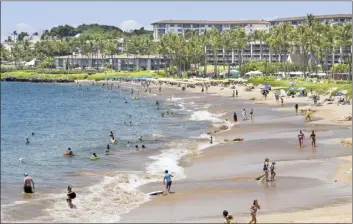  ?? The Maui News / MATTHEW THAYER photo ?? Visitor accommodat­ions in Wailea can be seen in the background as visitors flock to the beach in this 2021 photo. The Maui County Council will take up a bill on second and final reading next week that would repeal the current temporary moratorium on tourists accommodat­ions.