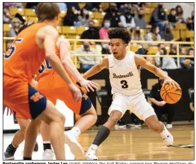  ?? (Special to the NWA Democrat-Gazette/David Beach) ?? Bentonvill­e sophomore Jaylen Lee (right) dribbles the ball Friday against two Rogers Heritage defenders during the Tigers’ 82-50 victory in Bentonvill­e. Lee led the Tigers with 18 points.