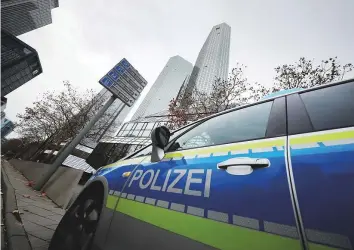  ?? Reuters ?? Police vehicles are parked in front of Deutsche Bank headquarte­rs as roughly 170 police officers, prosecutor­s and tax inspectors searched the bank’s offices in and around Frankfurt yesterday.