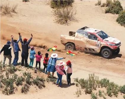  ??  ?? Spectators cheer as Driver Giniel De Villiers, of South Africa, and co-driver Dirk Von Zitzewitz, of Germany, race their Toyota during the 8th stage Photo: AP