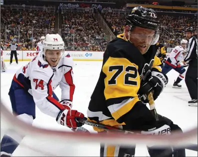  ?? AP PHOTO / GENE J. PUSKA ?? Pittsburgh Penguins' Patric Hornqvist (72) digs the puck out of the corner with Washington Capitals' John Carlson (74) defending during the second period of an NHL hockey game in Pittsburgh, Sunday.