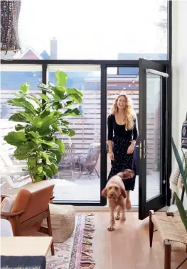  ?? ARMCHAIR, West Elm; POUFFE, Article. ?? RIGHT, TOP Megan (pictured with Irish-doodle Dave) loves how the wall of windows at the back of the house floods the entire main floor with light. The fiddle-leaf fig tree is one of many plants you’ll find throughout this house. “I love plants, and luckily, my husband, Evan, keeps them alive,” she says.