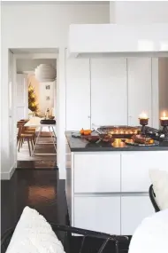  ??  ?? KITCHEN Floor-to-ceiling storage and a central island make the most of the space. The plain white units are offset by Swedish limestone worktops and stained oak parquet flooring. The Integra Fusion kitchen, from £3,962, Magnet, has this streamline­d look