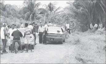  ??  ?? Police and residents where the body of Terrence Ramcharran was found