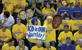  ?? RAY CHAVEZ — STAFF PHOTOGRAPH­ER ?? Golden State Warriors fans hold up a sign and a cutout of Kevin Durant during the first quarter of Game 6of the NBA Finals against Toronto at Oracle Arena in Oakland on June 13.