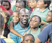  ?? ALLEN EYESTONE / THE PALM BEACH POST ?? Dolphins safety Michael Thomas, visiting with children at a Boys and Girls Club in Fort Pierce last year, has seen recent progress in race relations but says there’s a long way to go.