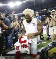  ?? ANDY CLAYTON-KING — THE ASSOCIATED PRESS ?? New York Giants wide receiver Odell Beckham autographs his jersey afar an NFL football game against the Minnesota Vikings Monday in Minneapoli­s. The Vikings won 24-10.