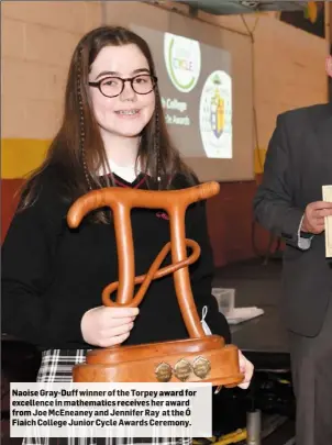  ??  ?? Naoise Gray-Duff winner of the Torpey award for excellence in mathematic­s receives her award from Joe McEneaney and Jennifer Ray at the Ó Fiaich College Junior Cycle Awards Ceremony.