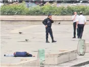  ??  ?? Police stand by beside the downed attacker outside the cathedral, above, while visitors to the holy site were kept inside for their safety, left