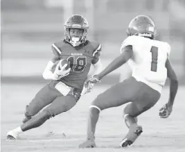  ?? ANDREW ULOZA For the Miami Herald ?? Miramar wide receiver Chadman Greaves, left, looks to avoid a tackle by Edison defensive back Elgrin Terma during a jamboree game Friday at Miramar High School.