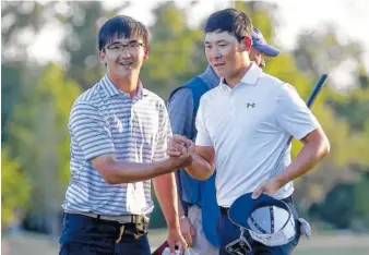  ?? PHOTO BY MICHAEL DEMOCKER/NOLA.COM THE TIMES-PICAYUNE VIA AP ?? Dou Zecheng, left, and Zhang Xinjun Zhang celebrate after Dou sank a long birdie on the final hole to put the duo into a first-place tie at the end of the first round of the Zurich Classic golf tournament at TPC Louisiana on Thursday in Avondale, La.