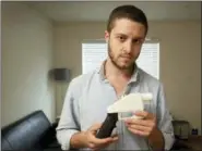  ?? JAY JANNER/AUSTIN AMERICAN-STATESMAN VIA AP, FILE ?? In this 2013 file photo, Cody Wilson, the founder of Defense Distribute­d, shows a plastic handgun made on a 3D-printer at his home in Austin, Texas. Eight states filed suit Monday, July 30, against the Trump administra­tion over its decision to allow a Texas company to publish downloadab­le blueprints for a 3D-printed gun, contending the hard-totrace plastic weapons are a boon to terrorists and criminals and threaten public safety.