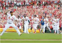  ?? AFP-Yonhap ?? St. Louis Cardinals’ teammates celebrate winning the National League Central Division after beating the Chicago Cubs at Busch Stadium on Sunday in St Louis, Mo.