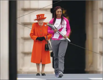  ?? (AP/Matt Dunham) ?? Baton bearer Britain’s Kadeena Cox, who won two gold medals at the Rio 2016 Paralympic Games, receives the baton from the queen at the event.