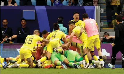  ?? ?? Malaysia's Romel Morales is buried under his jubilant teammates after scoring the late equaliser. Photograph: Thaier Al-Sudani/Reuters