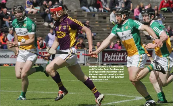  ??  ?? Wexford’s Diarmuid O’Keeffe taking on Offaly duo Seán Gardiner and Seán Ryan on the run which led to the controvers­ial penalty scored by Mark Fanning but not awarded in Saturday’s clash.