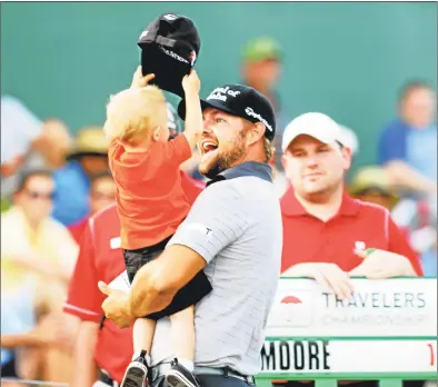  ?? Hearst Connecticu­t Media file photo ?? Ryan Moore is greeted by his son, Tucker, after the 18th hole while leading the 2014 Travelers after the third round.