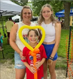  ?? Hanna Webster ?? Jen Stoyer, 40, with her kids Madi, 12, and Jackson, 9. Jen has attended the festival for her whole life and has now included her children in the tradition. Her mother was raised in a house on 39th street.
