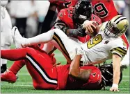  ?? AP PHOTO BY DANNY KARNIK ?? Atlanta Falcons defensive tackle Dontari Poe, bottom, and Atlanta Falcons defensive tackle Grady Jarrett sack New Orleans Saints quarterbac­k Drew Brees during the second half of Thursday's football game in Atlanta.