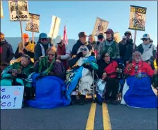  ?? AP PHOTO/CALEb JOnES ?? Demonstrat­ors gather to block a road at the base of Hawaii’s tallest mountain, on Monday, in Mauna Kea, Hawaii, to protest the constructi­on of a giant telescope on land that some Native Hawaiians consider sacred.