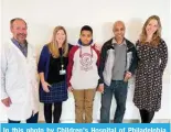  ?? — AFP ?? In this photo by Children’s Hospital of Philadelph­ia, healthcare providers pose for a photo with Aissam Dam, 11-year-old patient who received the gene therapy treatment (center) and his father Youssef Dam (right center).