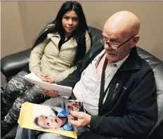  ?? MICHELLE BERG ?? Ted (Henry) Parker is joined by his wife, Maria, as he flips through government forms and photos of his eight-month-old step-grandson, Jepherson. The child lives in the Dominican Republic and was denied a temporary resident visa to visit Canada to see...