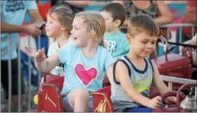  ?? GENE WALSH — DIGITAL FIRST MEDIA ?? Children wave to their parents as they enjoy an amusement ride during the Community Fair at St. Teresa of Calcutta in Limerick.