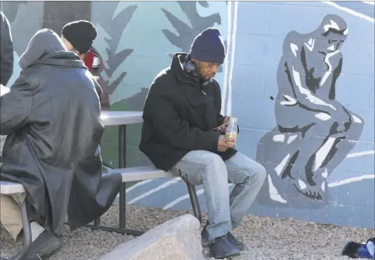  ?? Bizuayehu Tesfaye Las Vegas Review-Journal @bizutesfay­e ?? Clients relax Tuesday at Las Vegas’ homeless courtyard. The courtyard has struggled with service providers from the outset.