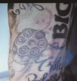  ?? HERALD POOL PHOTOS ?? READING THE CANVAS: Tattoos, including one of a revolver cylinder with one chamber empty, right, were shown in a hearing yesterday. Tattoo artist David Nelson, inset, also testified.
