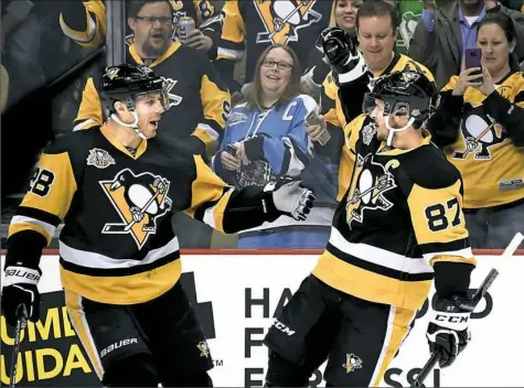  ?? Peter Diana/Post-Gazette ?? Captain Sidney Crosby celebrates with teammate Ian Cole after scoring in the first period against the Ottawa Senators Monday at PPG Paints Arena.
