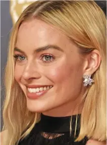  ??  ?? AUSTRALIAN actress Margot Robbie, 27, paired her Givenchy gown with large Harry Winston diamonds. The spiked floral design drew attention towards her face. She tucked her hair behind her ear to ensure the five-figure earrings — featuring six...