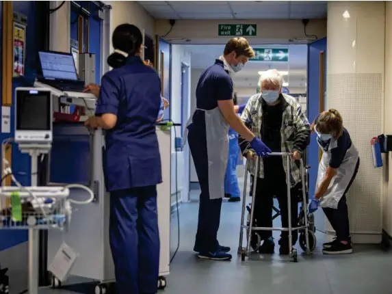  ?? (Getty) ?? Staff at Headley Court hospital in Surrey help a virus patient recover