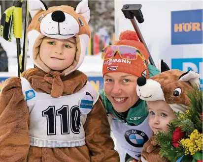  ?? FOTO: IMAGO ?? Einfach mal die Weltmeiste­rin in die Mitte nehmen: Laura Dahlmeier posiert nach dem Staffelsie­g mit zwei kleinen Maskottche­n des Ruhpolding­er Weltcups.
