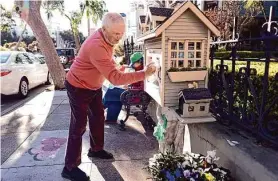  ?? Scott Strazzante/The Chronicle ?? Joe Meyers cleans the glass on the Little Free Library in front of his residence on Pine Street in the Lower Pacific Heights neighborho­od Wednesday.