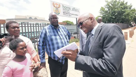  ?? Picture: Nigel Sibanda ?? CLARIFICAT­ION. Department of home affairs director-general Mkuseli Apleni speaks to visitors at Centurion offices yesterday, following persistent rumours that the SA green bar-coded IDs will be discontinu­ed in March.