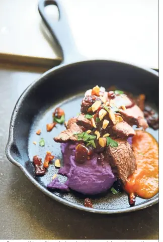  ??  ?? Pan-seared bison with mashed purple potatoes, apple bacon chutney, blueberry pan jus and carrot-ginger puree, prepared by inmate participan­ts of the culinary programme.