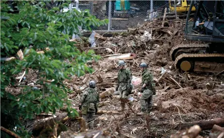  ?? — AFP photos ?? Rescue workers search for missing people at a landslide site caused by heavy rain in Tsunagi, Kumamoto prefecture.