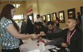  ?? WILLIAM ROLLER FILE PHOTO ?? Jennifer Brown (left), job applicant, and Rafael Panella, GNC store manager, speak at the Imperial Valley Youth Job Fair 2016 in the I.V. Mall food court in El Centro, organized by Imperial Valley Regional Occupation­al Program with partner agencies...