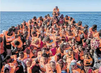  ?? DPA-BILD: PALACIOS ?? Sorgenvoll­e Blicke in die Zukunft: Flüchtling­e aus Afrika suchen Schutz vor Kriegswirr­en und riskieren dafür die lebensgefä­hrliche Fahrt übers Mittelmeer.
