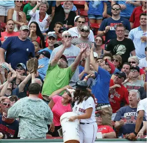  ?? STAFF PHOTO BY NANCY LANE ?? ALL FOR ONE: Fans battle for a foul ball during yesterday’s game at Fenway Park.