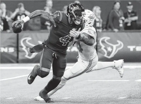  ?? Karen Warren / Staff photograph­er ?? Texans quarterbac­k Deshaun Watson, left, slip out of the grasp of Dolphins defensive end Robert Quinn during this run in the third quarter of Thursday’s game.