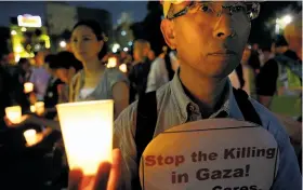  ?? Shizuo Kambayashi / Associated Press ?? Japanese protesters hold candles during a demonstrat­ion in Tokyo against Israel’s military offensive in the Gaza Strip.