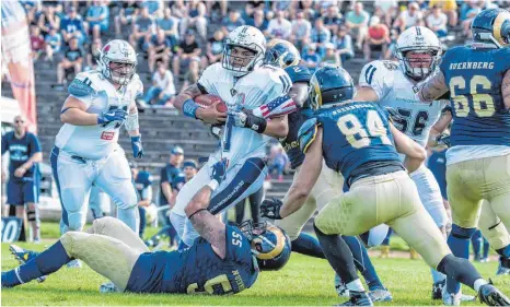  ?? FOTO: FLORIAN WOLF ?? Will Benson (Mitte), Quarterbac­k der Ravensburg Razorbacks, wurde im Zweitligas­piel von den Nürnberg Rams (unten Darren Rechenbach) oftmals massiv unter Druck gesetzt.