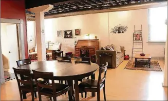  ??  ?? The dining room transition­s into the combined living and family room. The large windows allow for natural light, and the painted brick walls give the room character.