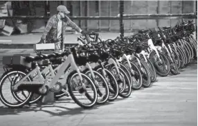  ??  ?? Phillip Smith adds a bicycle to a row of others as he works with a group of volunteers as they unpack a fleet of 600 bikes for the Explore Bike Share in an Uptown warehouse on Feb. 6. YALONDA M. JAMES/THE COMMERCIAL APPEAL