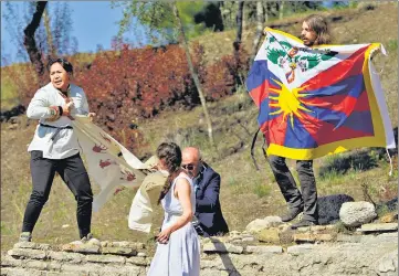  ?? AP ?? A police officer tries to stop protesters from displaying a Tibetan flag and a banner reading “No Genocide Games” during the lighting of the Olympic flame at Ancient Olympia in Greece on Monday. Beijing will host the Winter Olympics from February 4-20 in 2022.