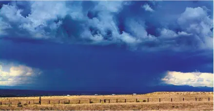  ?? GREG SORBER/ JOURNAL ?? Rain falls north of Albuquerqu­e on Monday afternoon as cars move along Tramway Road NE through Sandia Pueblo. More rain is expected this week, especially Wednesday through Friday.