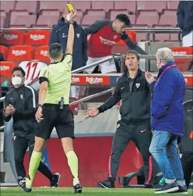  ??  ?? Sánchez Martínez muestra una amarilla al banquillo del Sevilla en el Camp Nou.
